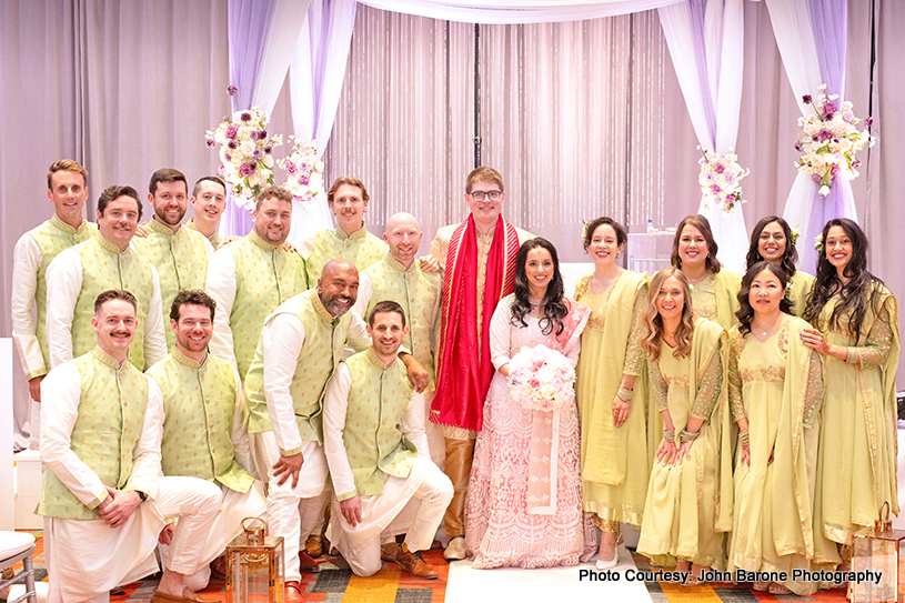 Indian newlyweds posing with bridesmaids and groomsmen